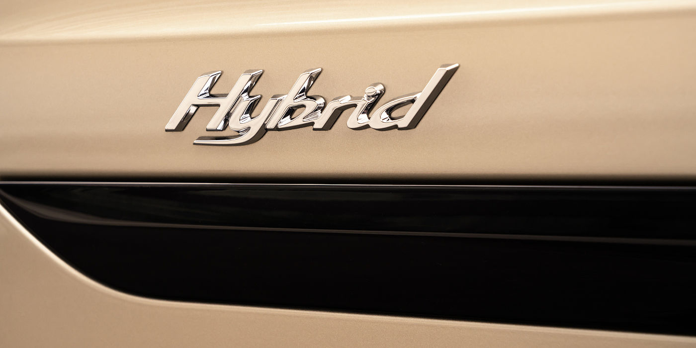 new-bentley-bentayga-hybrid-in-patina-paint-showing-chrome-hybrid-badge-close-up 