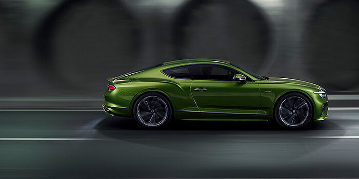 Bentley Bangkok Bentley Continental GT coupe in Tourmaline Green paint driving in profile on a dark road