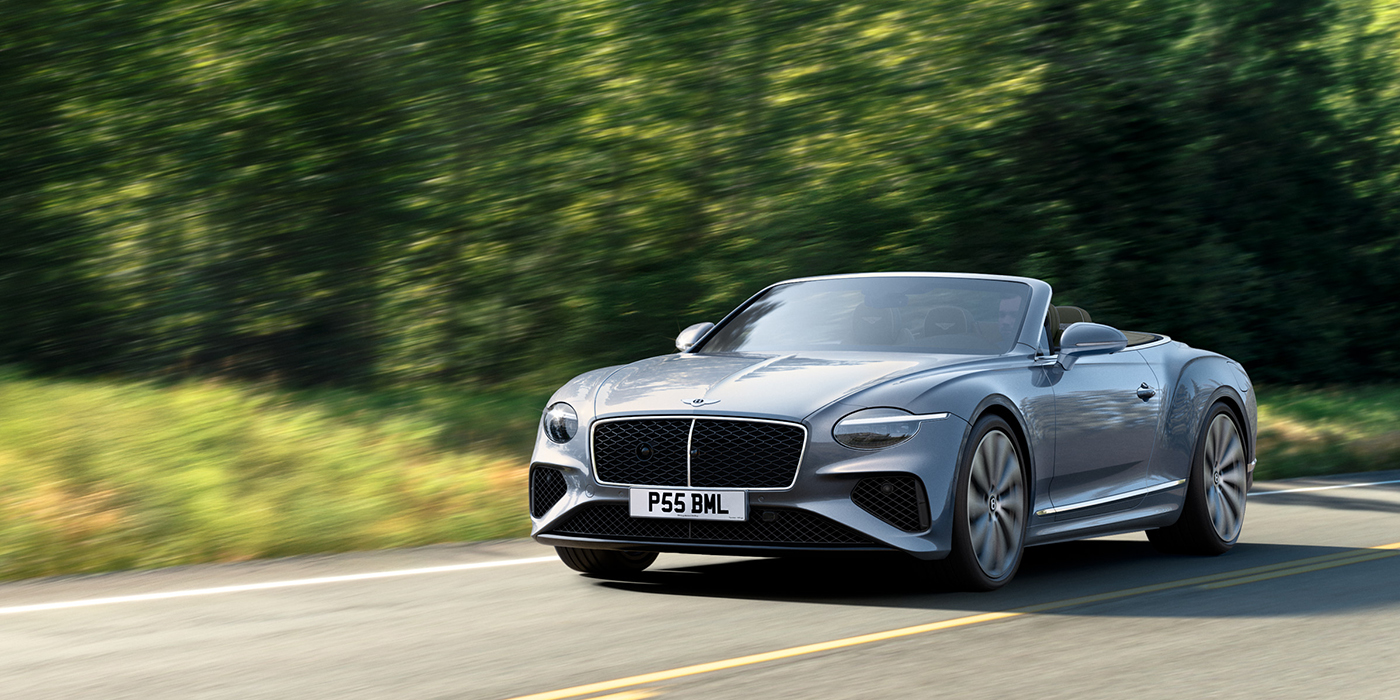 Bentley Bangkok New Bentley Continental GTC convertible front view in Silverlake paint with 22 inch ten spoke wheels, driving dynamically on a country road